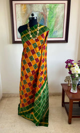 TVESHA- ORANGE GHARCHOLA WITH BANDHANI CHOWK AND GREEN BORDER