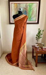 JOVITHA- RUST BROWN KANJIVARAM, SUBTLE CHARM, OFF-WHITE BORDER, VIBRANRT GREEN MOTIFS