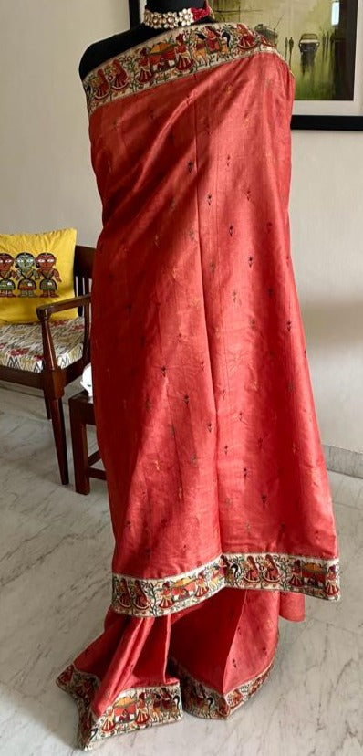TASHI- A BEAUTFUL BURNT ORANGE TUSSAR SILK WITH SMALL FLORAL MOTIFS EMBROIDERED IN THE BODY AND DANCING GIRLS EMBROIDERED IN THE BORDER AND AANCHAL
