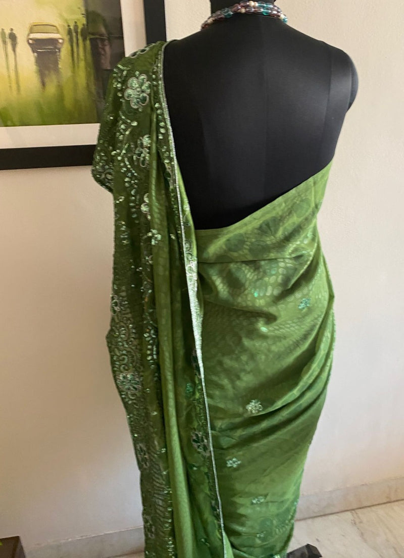 SITARA- A STYLISH OLIVE GREEN GEORGETTE SAREE WITH SEQUINS AND EMBROIDERY ALONG THE BORDER AND AANCHAL