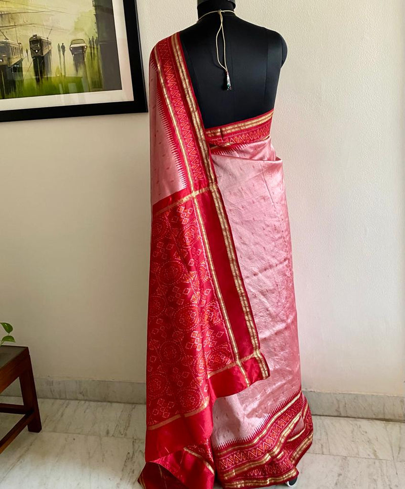 AARNA- ENCHANTING ELEGANCE OF PEACHISH PINK SILK SAREE WITH VIBFANT RED PATOLA IKKAT AANCHAL AND INTRICATE WOVEN BOOTIS