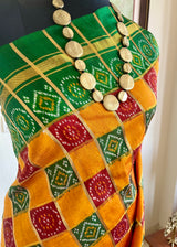 TVESHA- ORANGE GHARCHOLA WITH BANDHANI CHOWK AND GREEN BORDER