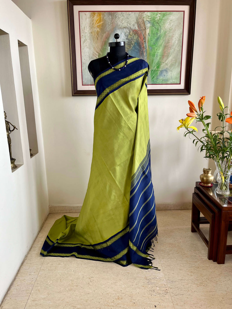 SAYURI – LEAF GREEN KORVAI KANJIVARAM WITH NAVY BLUE BORDERS