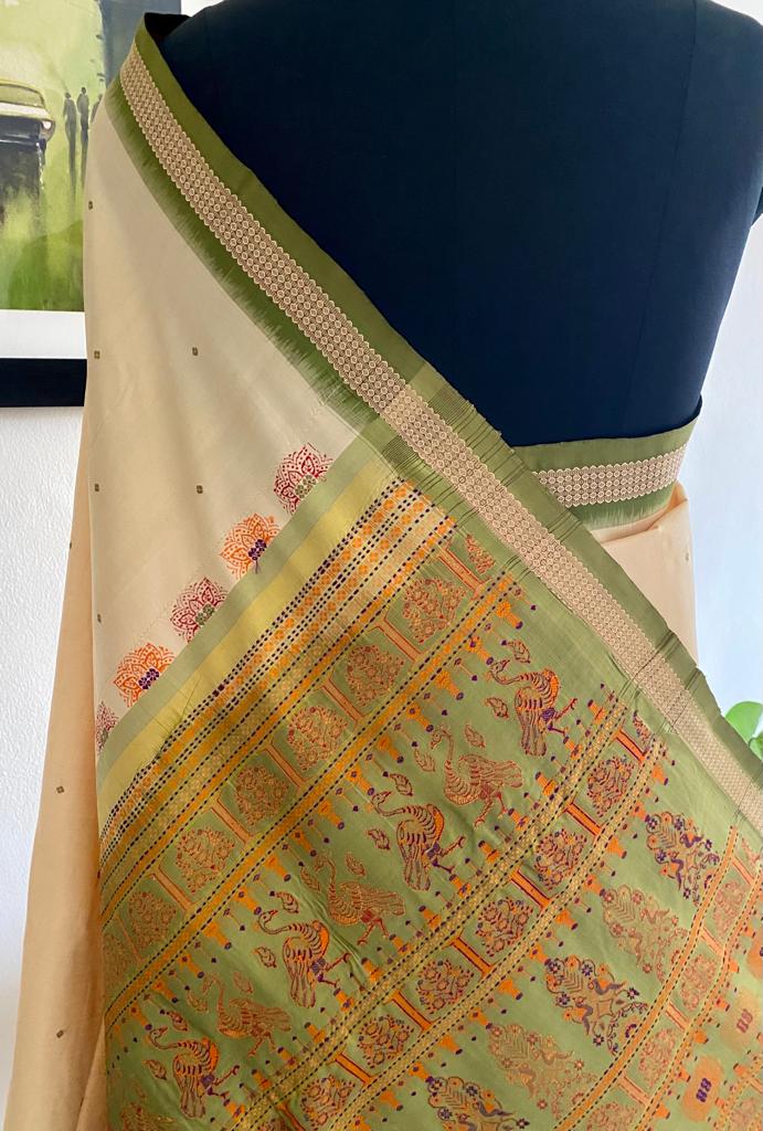 ANASUYA- AN OFFWHITE/CREAM HANDLOOM, PURE SILK BOMKAI SAREE WITH VERY SMALL AND SCATTERED GREEN BOOTIS,  AN OFFWHITE AND GREEN BORDER AND A MULTI-COLOURED FULLY WOVEN AANCHAL