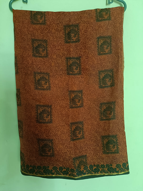 VRISHTI- A BRICK ORANGE, SILK, POWERLOOM SAREE WITH BLACK THREAD WOVEN PEACOCK BORDER, PRINTED BODY AND AANCHAL