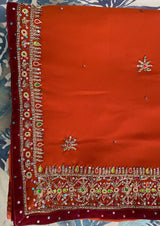 KESARIYA- A SEMI CREPE SAREE IN MUDDY ORANGE WITH ZARI FLOWERS ON THE BODY, STONE AND ZARI WORK ON THE BORDER.